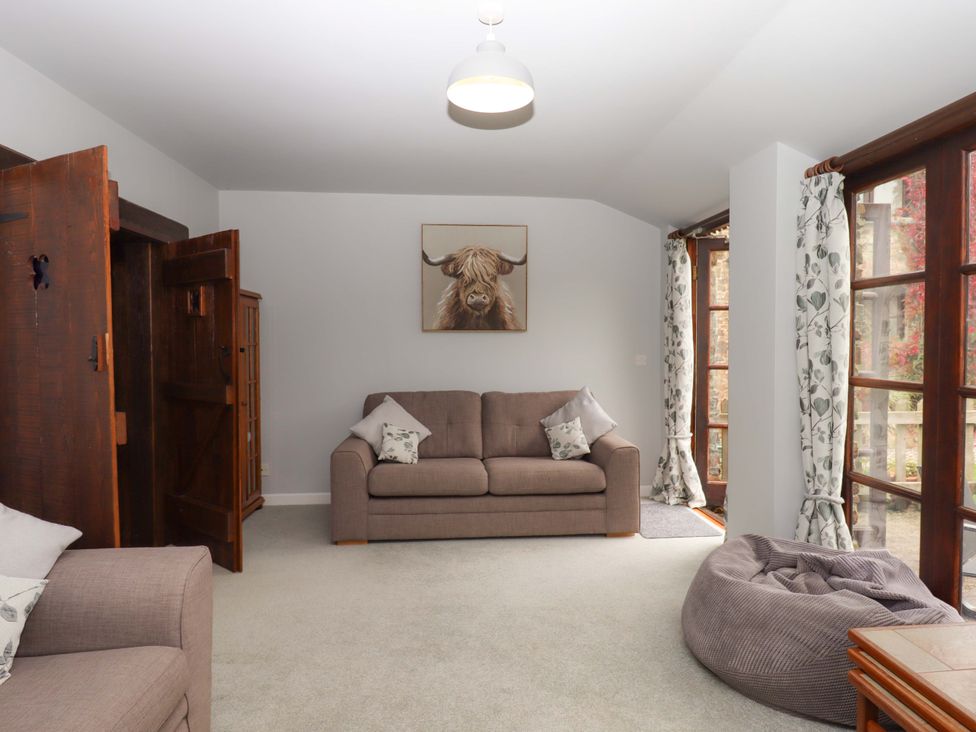 A living room with a sofa and a bean bag at The Milking Shippon at Thorne in Langtree near Great Torrington