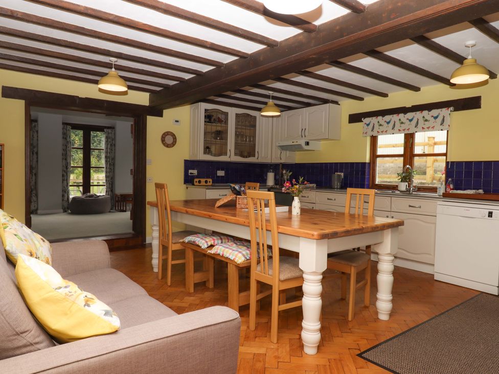 A kitchen with a dining table and chairs at The Milking Shippon at Thorne near Great Torrington