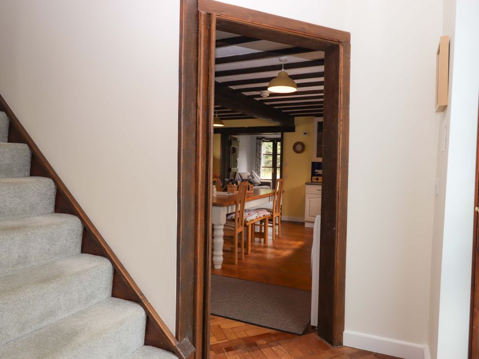 A hallway leading to a dining area with wooden furniture at The Milking Shippon at Thorne near Great Torrington