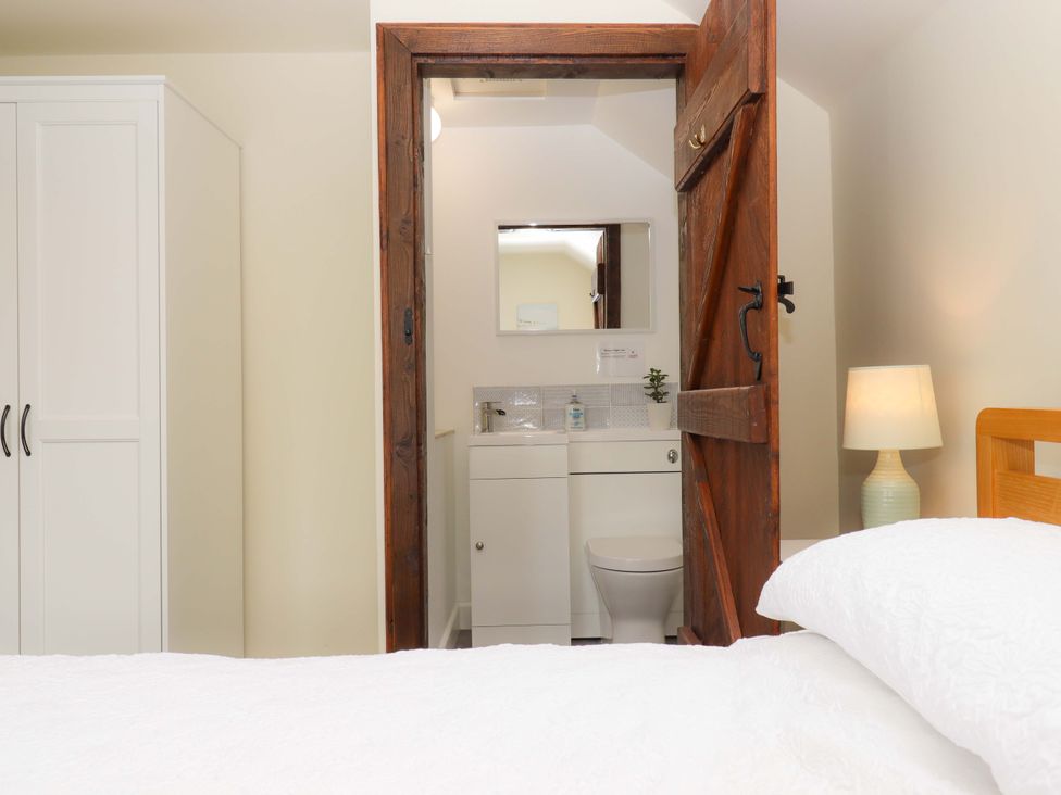 A bedroom with a view of a bathroom at The Milking Shippon at Thorne in Langtree near Great Torrington