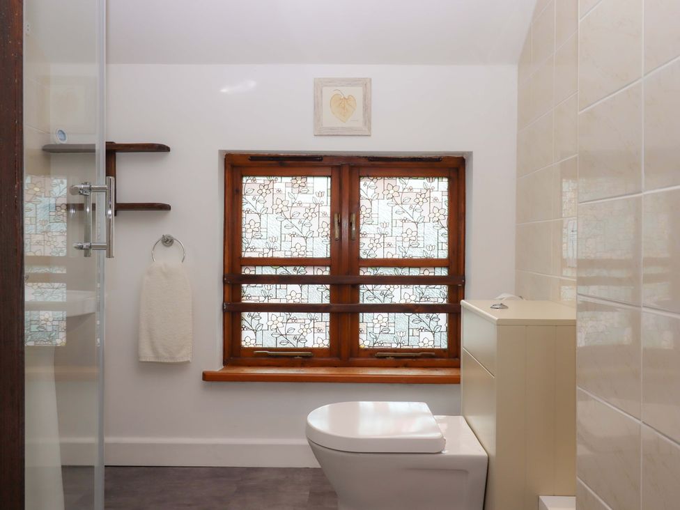 A bathroom with a toilet and a window at The Milking Shippon at Thorne, Langtree near Great Torrington