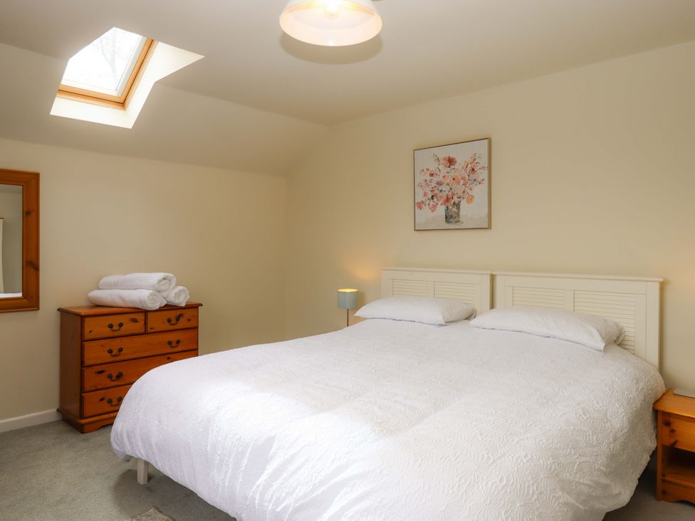 A bedroom with a bed and chest of drawers at The Milking Shippon at Thorne, Langtree near Great Torrington