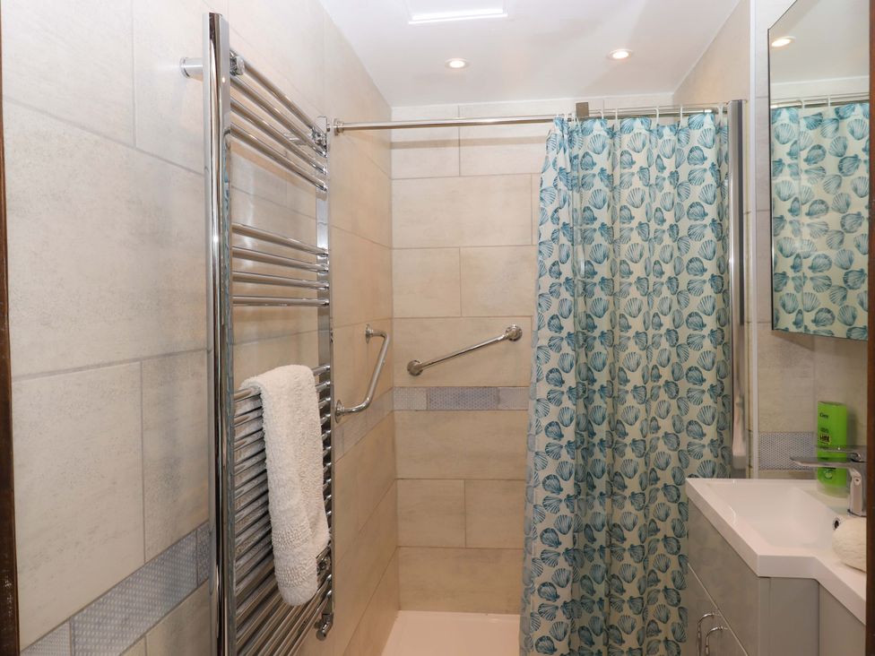 A bathroom with a shower and towel rail at The Milking Shippon at Thorne in Langtree near Great Torrington