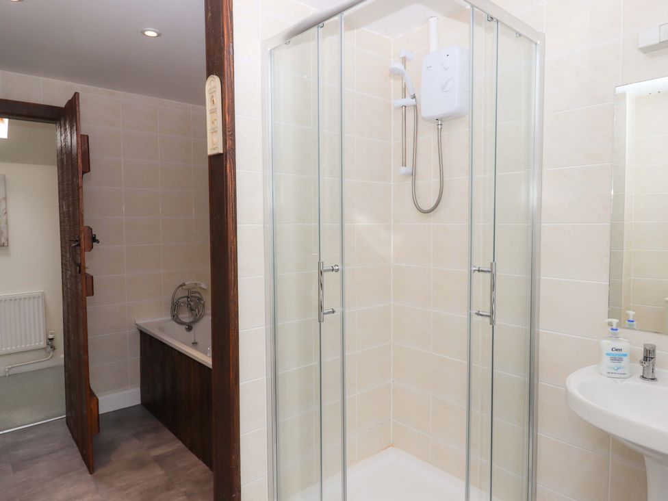 A bathroom with a shower, sink, and bathtub at The Milking Shippon at Thorne Langtree near Great Torrington