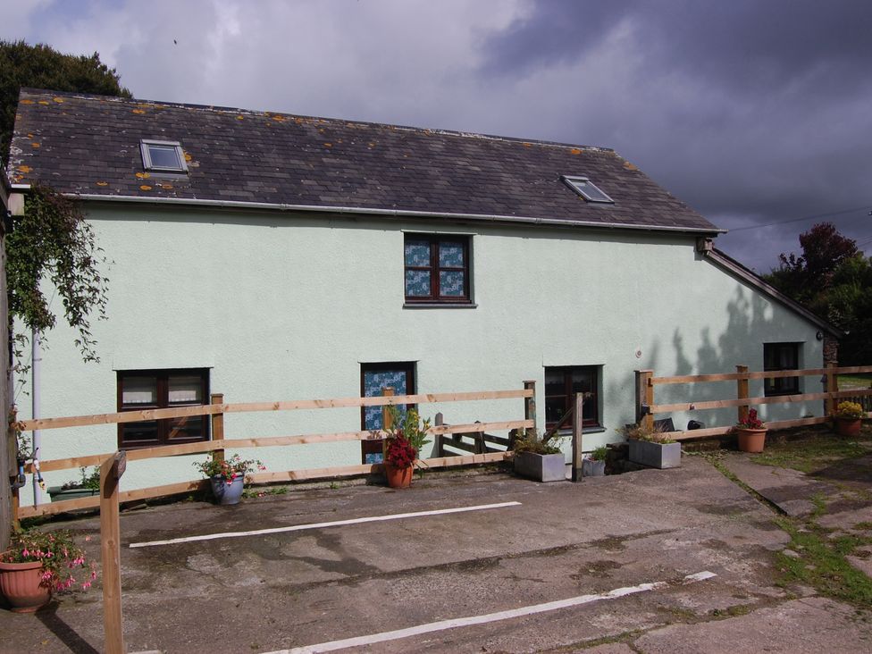 An outdoor area with a building and fence at The Milking Shippon at Thorne Langtree near Great Torrington
