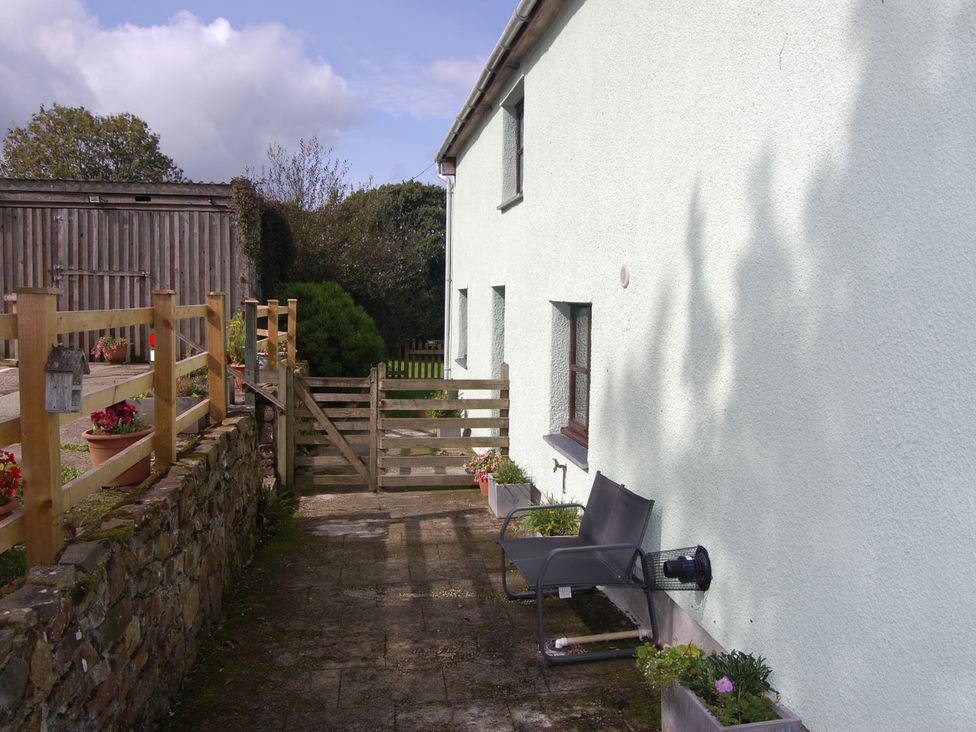 An outdoor area with a gate and chair at The Milking Shippon at Thorne near Great Torrington