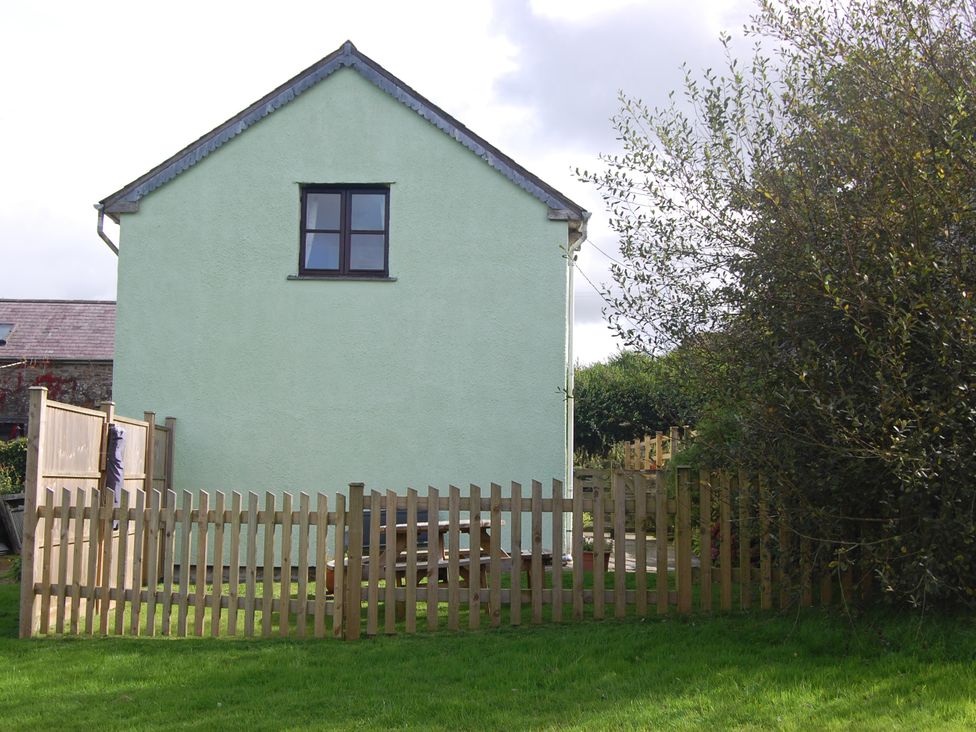 A house with a fence and garden furniture at The Milking Shippon at Thorne, Langtree near Great Torrington