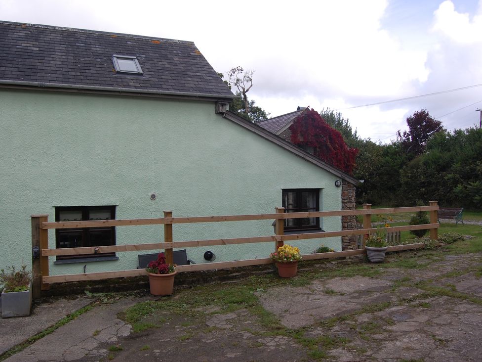 An outdoor area with a fence and flower pots at The Milking Shippon at Thorne in Langtree near Great Torrington
