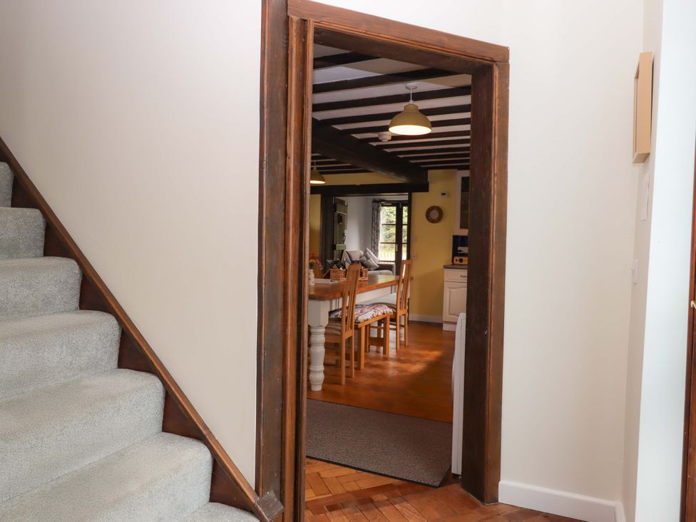 A doorway leading to a dining room with a table and chairs at The Milking Shippon at Thorne near Great Torrington