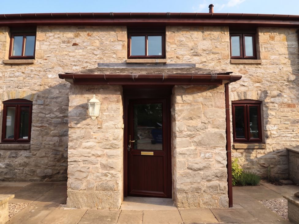 An entrance with a stone wall and door at Ty Cerrig apartment
