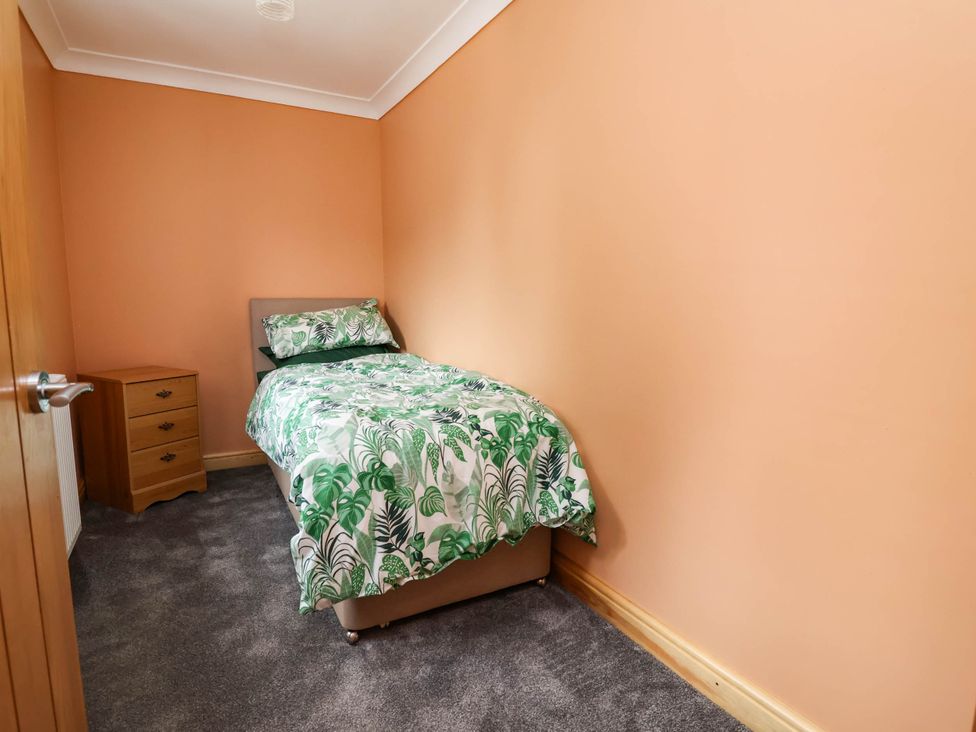 A bedroom with a single bed and a drawer at Ty Cerrig apartment