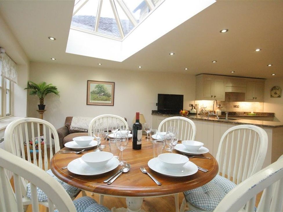 A dining room with a table set for dinner at The Coach House in Burford