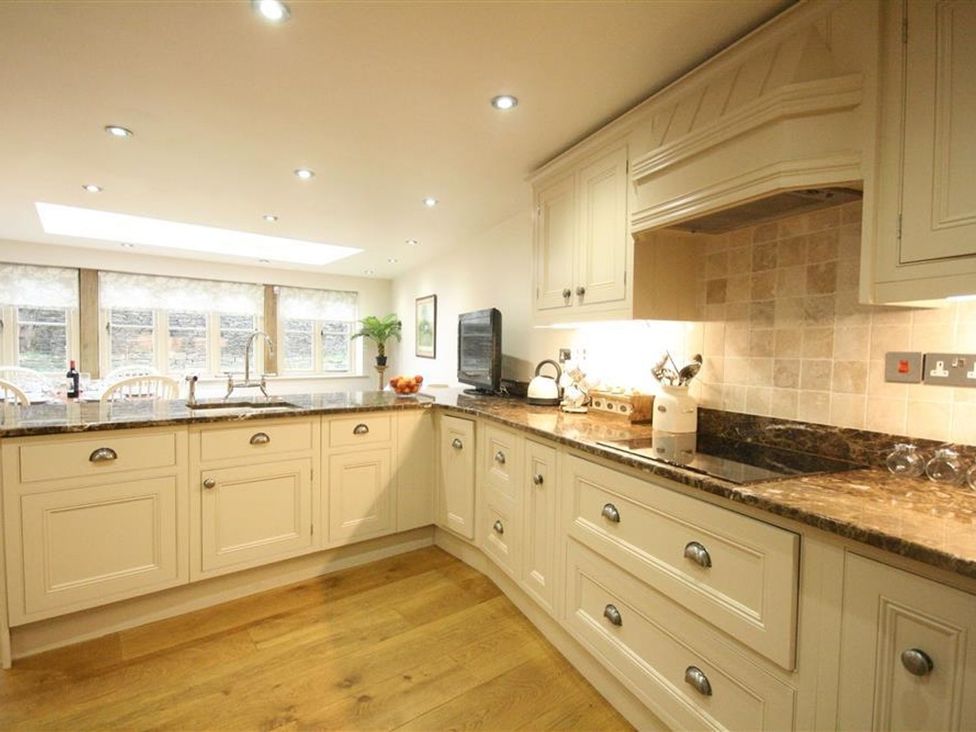 A kitchen with cabinets and a countertop at The Coach House in Burford