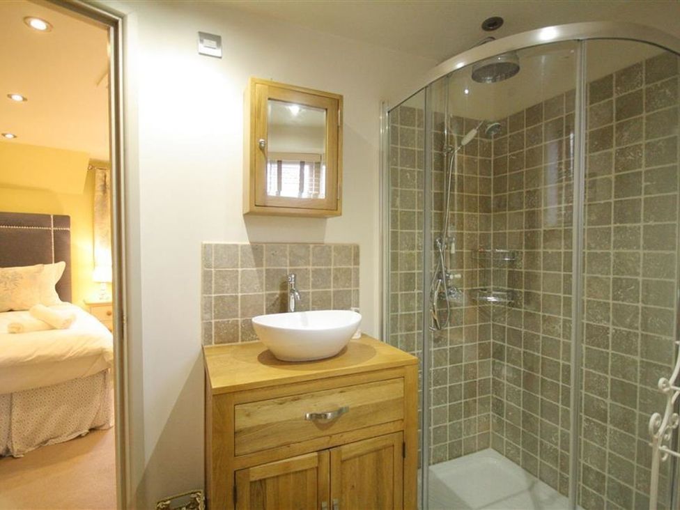 A bathroom with a shower and sink at The Coach House Burford