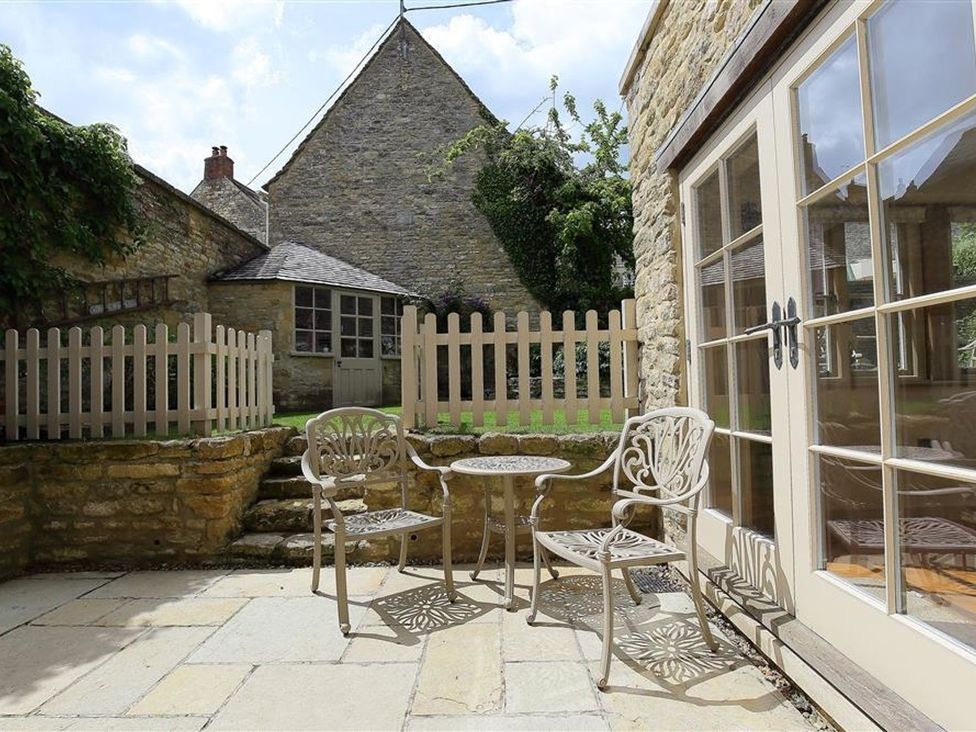 A garden with a table and chairs at The Coach House in Burford