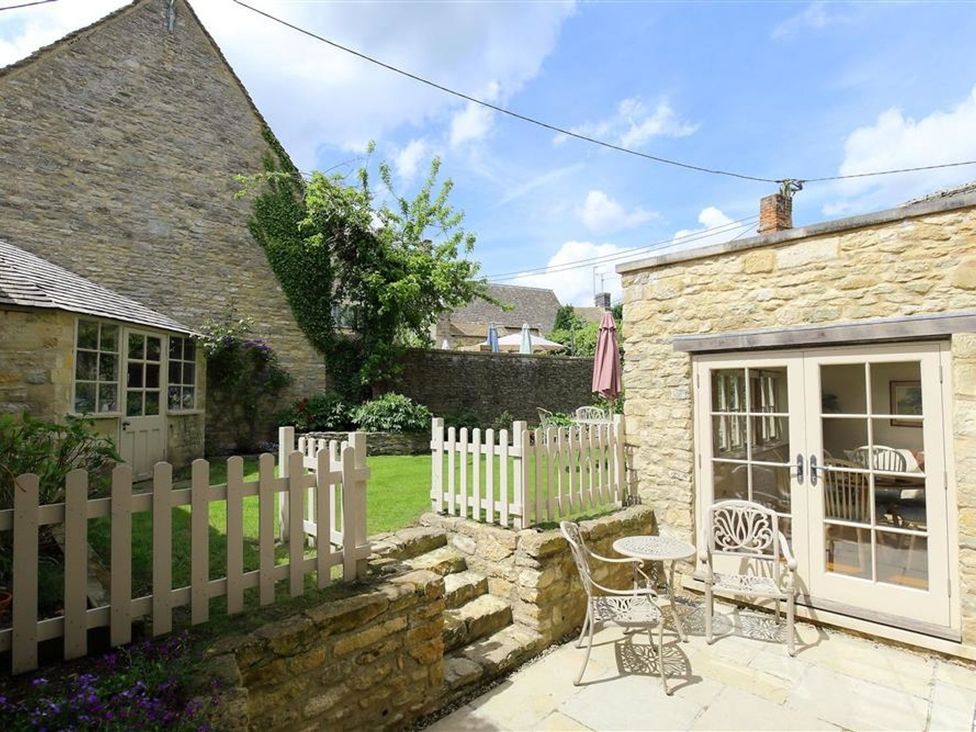A garden with a table and chairs at The Coach House in Burford