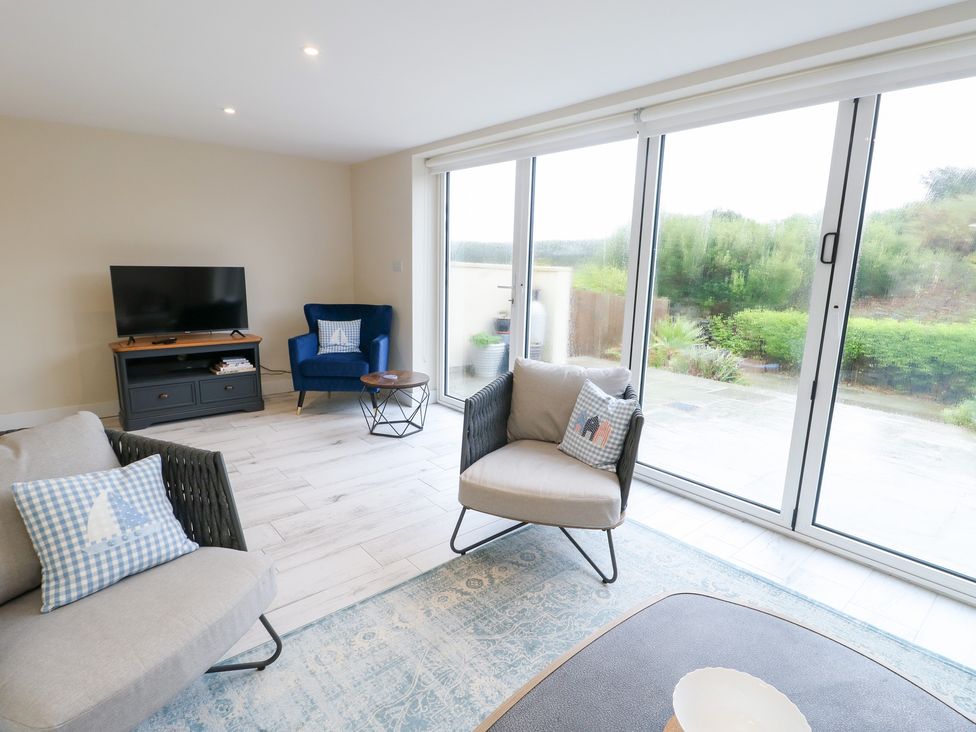 A living room with a television and seating at 2 Lon Y Dryw in Trearddur Bay