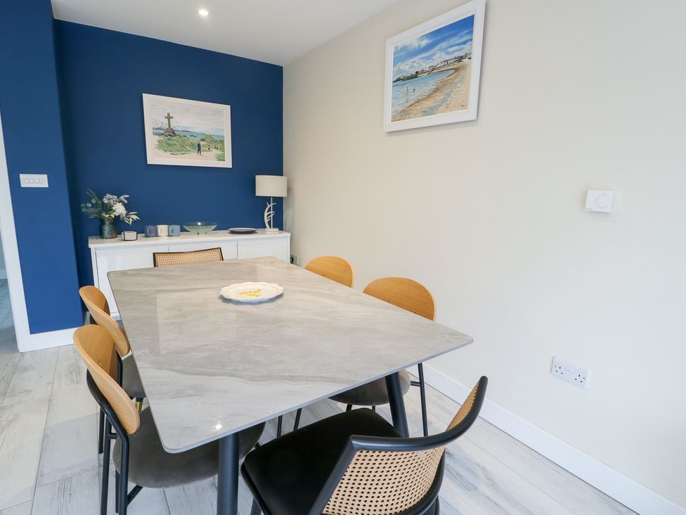 A dining room featuring a table and chairs with decor at 2 Lon Y Dryw in Trearddur Bay