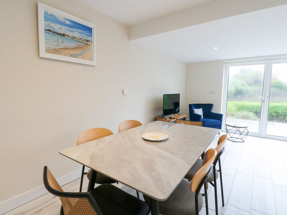 A dining room with a table and chairs at 2 Lon Y Dryw in Trearddur Bay