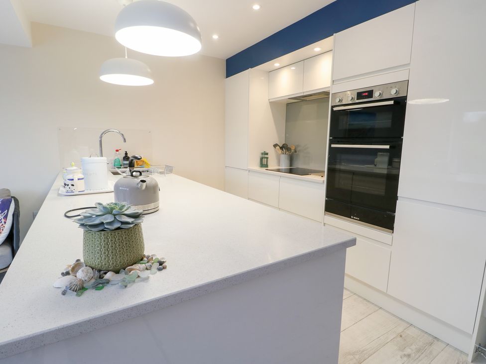 A kitchen with a sink and oven at 2 Lon Y Dryw in Trearddur Bay