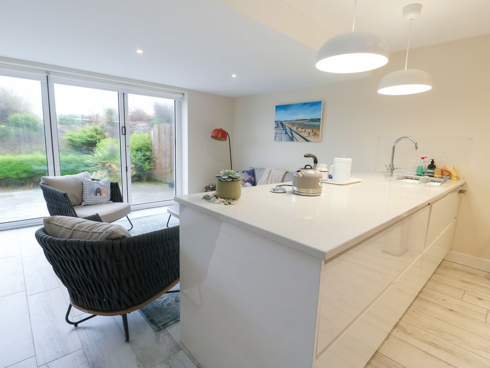 A kitchen with seating area and sliding glass doors at 2 Lon Y Dryw Trearddur Bay