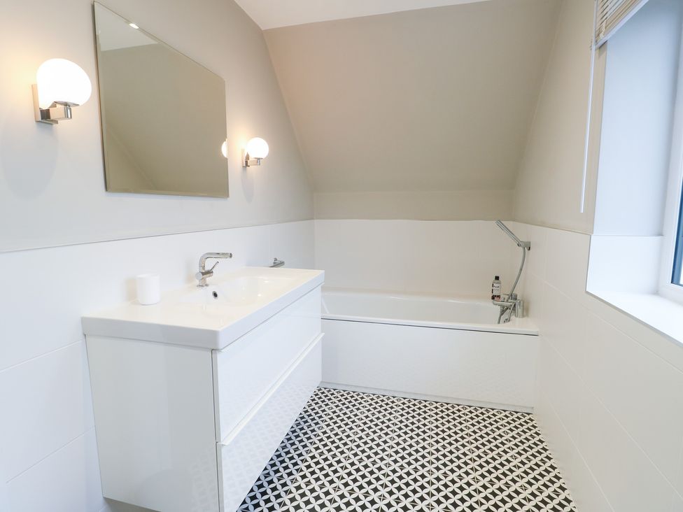 A bathroom with a wash basin and bathtub at 2 Lon Y Dryw in Trearddur Bay