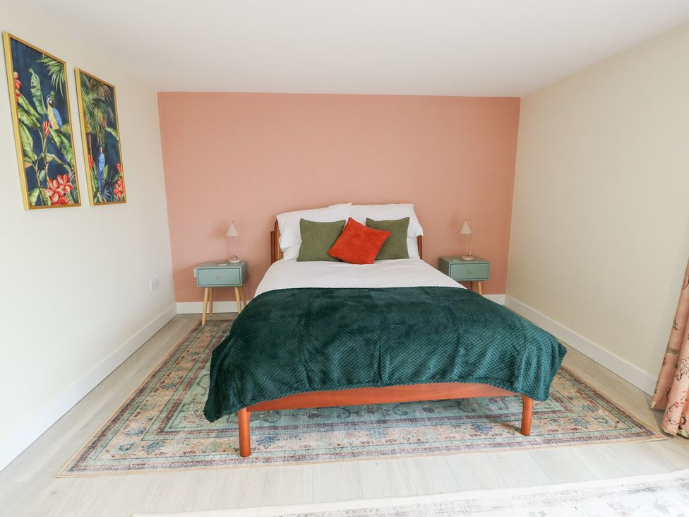 A bedroom with a bed and nightstands at 2 Lon Y Dryw Trearddur Bay