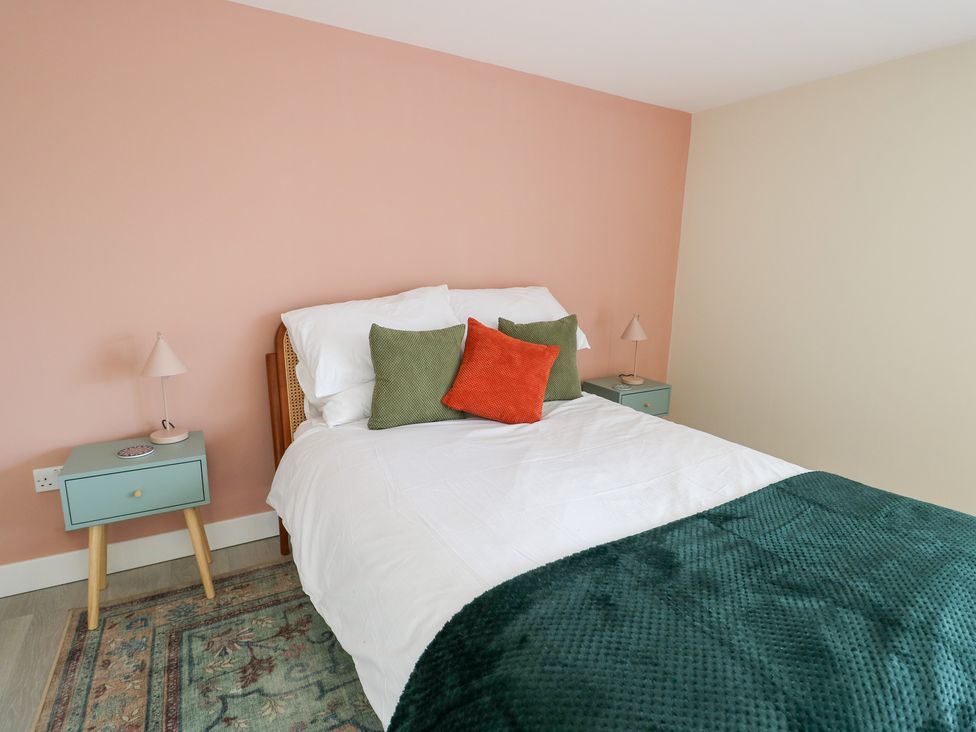 A bedroom with a bed and nightstand at 2 Lon Y Dryw in Trearddur Bay