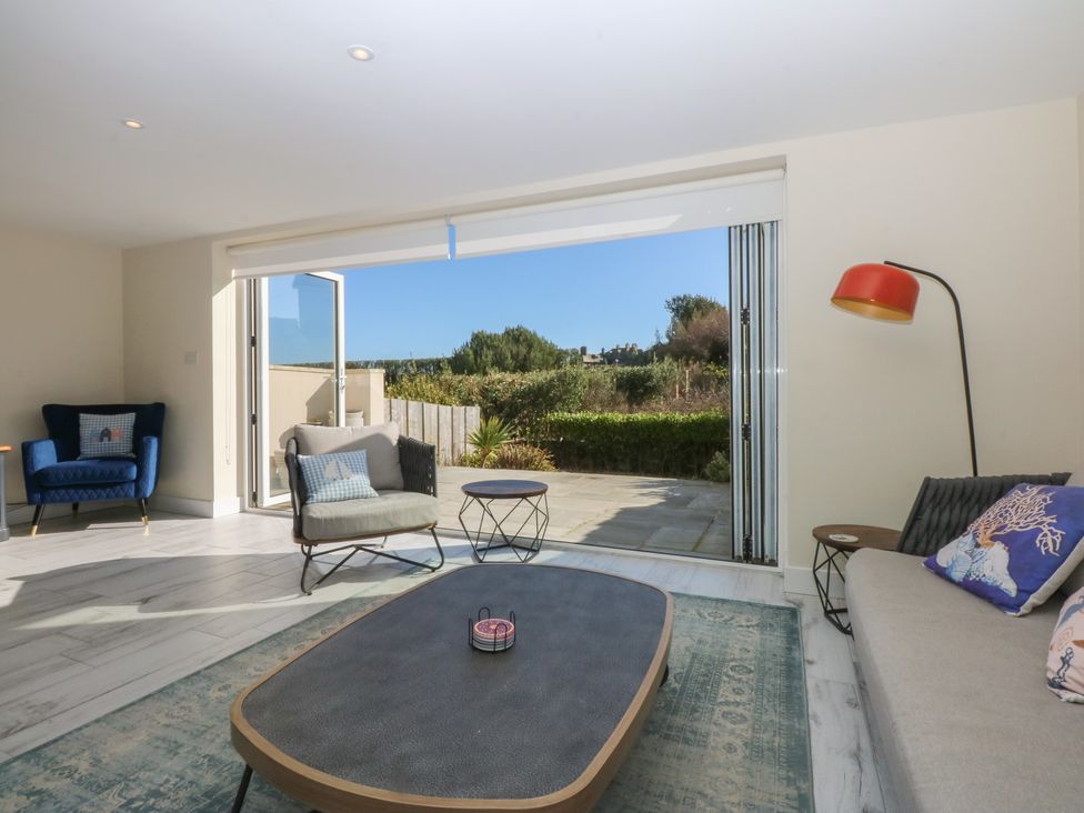 A living room with a sliding door leading to outdoor space at 2 Lon Y Dryw in Trearddur Bay