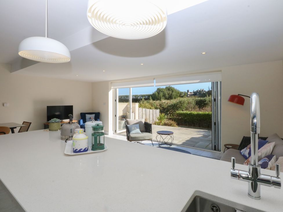A kitchen and living room area with a television at 2 Lon Y Dryw in Trearddur Bay