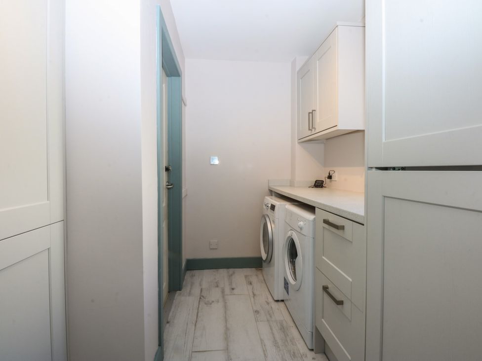 A laundry room with washing machine and dryer at 2 Lon Y Dryw in Trearddur Bay