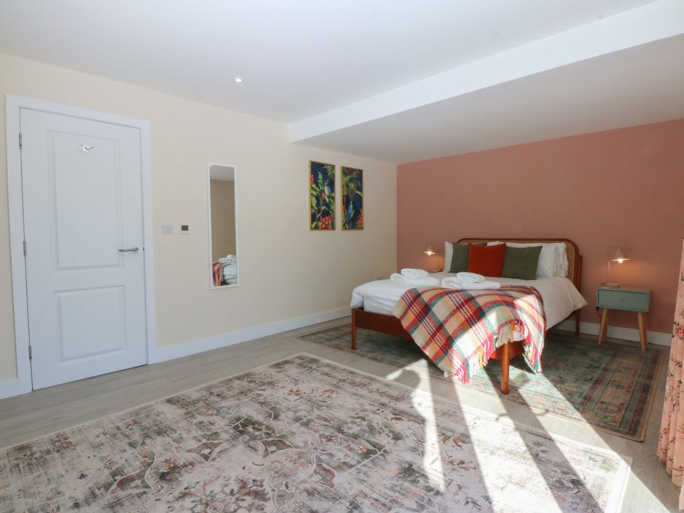 A bedroom with a bed and artwork at 2 Lon Y Dryw in Trearddur Bay