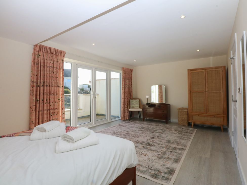 A bedroom with a bed, dresser, and wardrobe at 2 Lon Y Dryw, Trearddur Bay