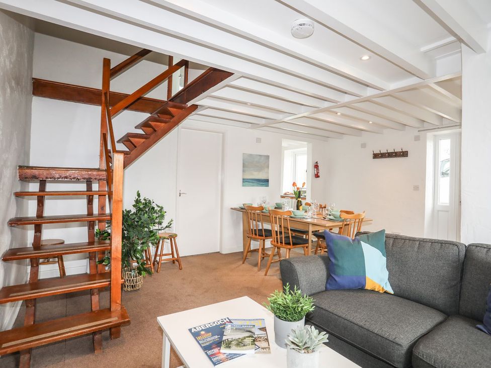 A living room with a staircase and dining area at Rhiw - 1 Ty'n Don Abersoch
