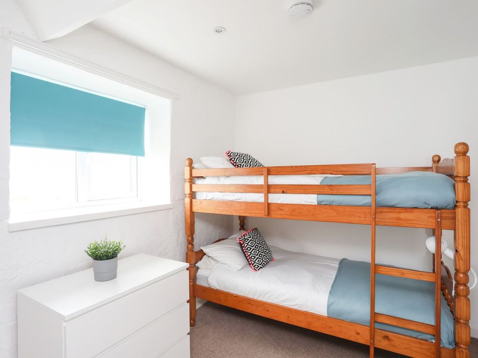A bedroom with a bunk bed and a dresser at Rhiw - 1 Ty'n Don, Abersoch