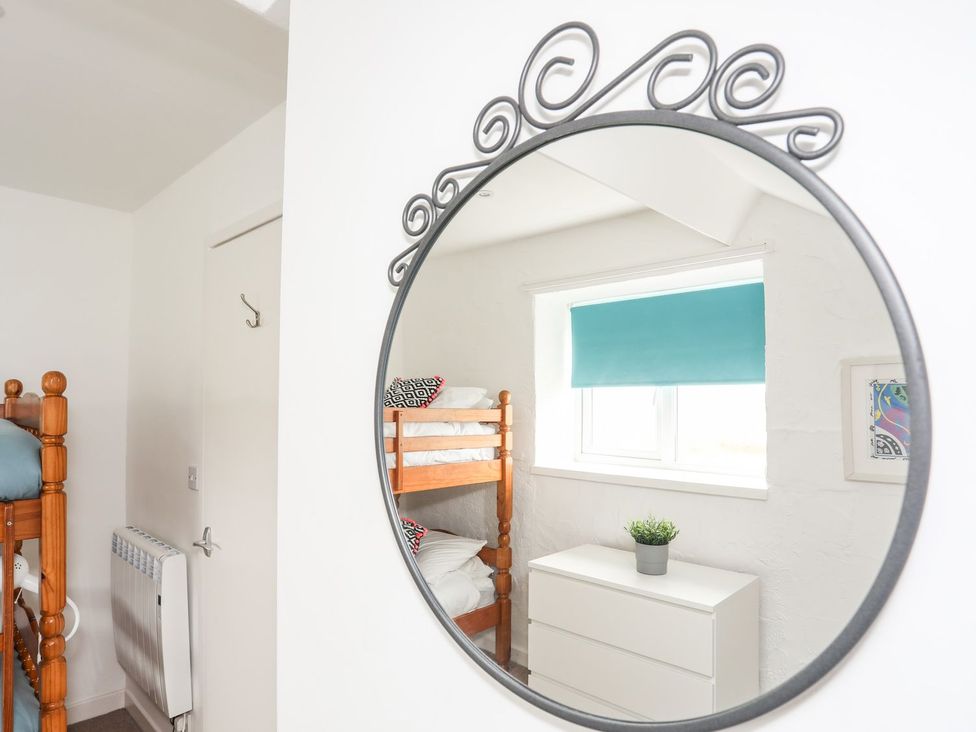 A bedroom with bunk beds and a chest of drawers at Rhiw - 1 Ty'n Don in Abersoch