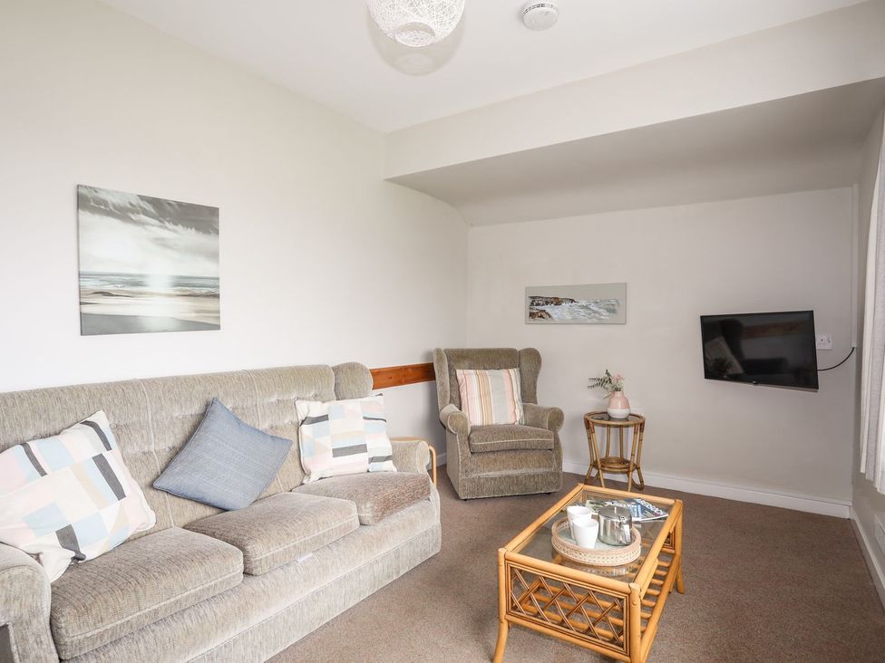 A living room with sofa, armchair, coffee table and television at Ceiriad - 9 Ty'n Don Llanengan near Abersoch