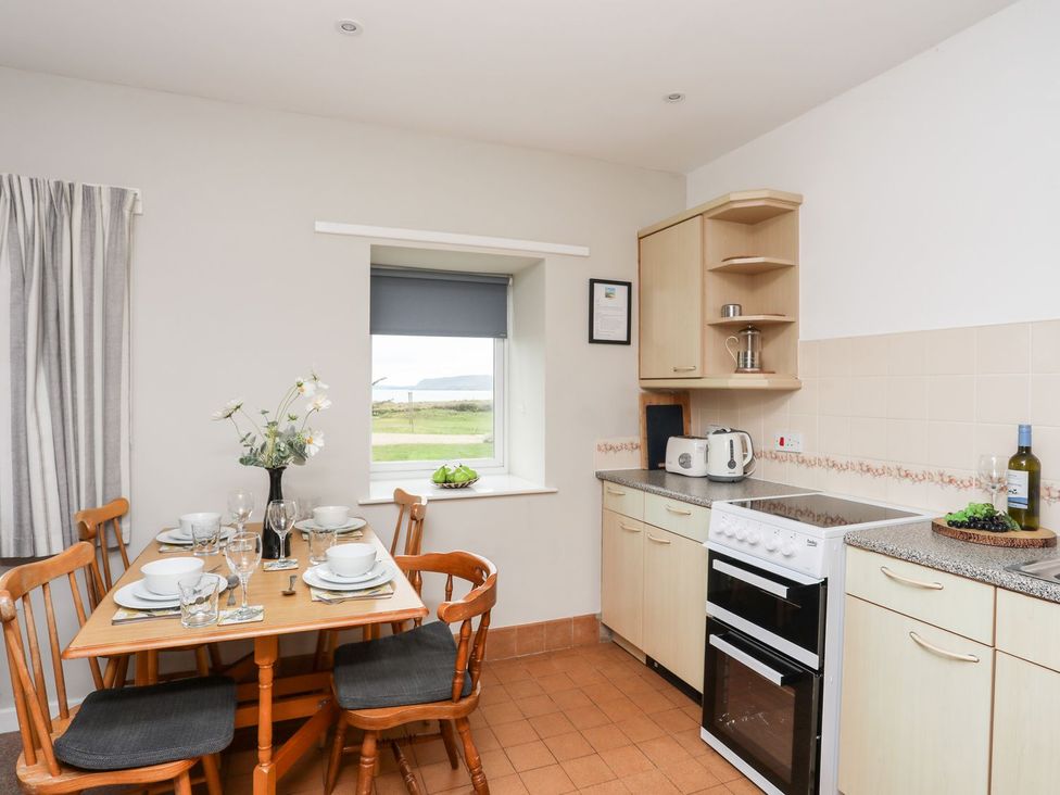 A kitchen with table and chairs at Ceiriad - 9 Ty'n Don near Llanengan