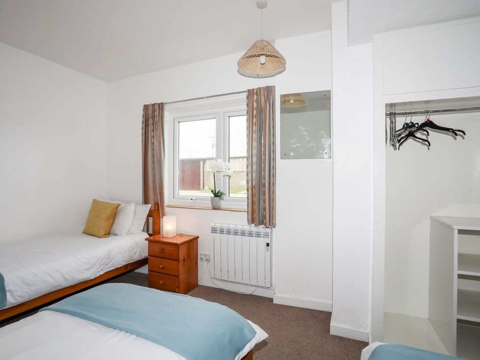 A bedroom with two beds and a window at Ceiriad - 9 Ty'n Don, Llanengan near Abersoch