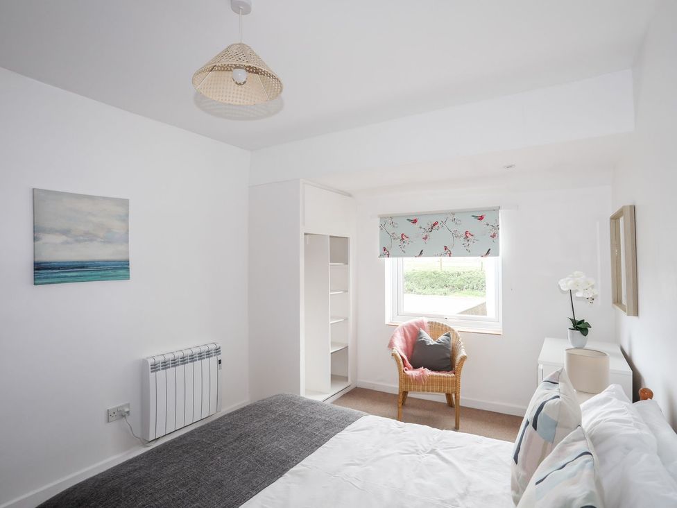 A bedroom with a bed and chair at Ceiriad - 9 Ty'n Don Llanengan near Abersoch