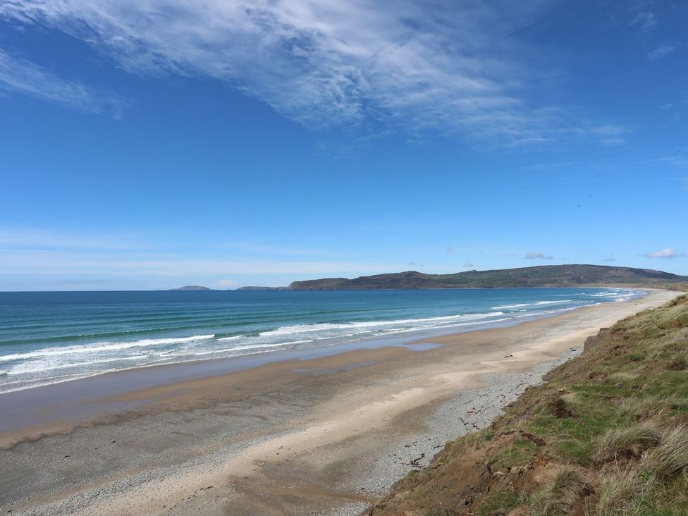 A beach with waves and hills in the background at Ceiriad - 9 Ty'n Don Llanengan near Abersoch