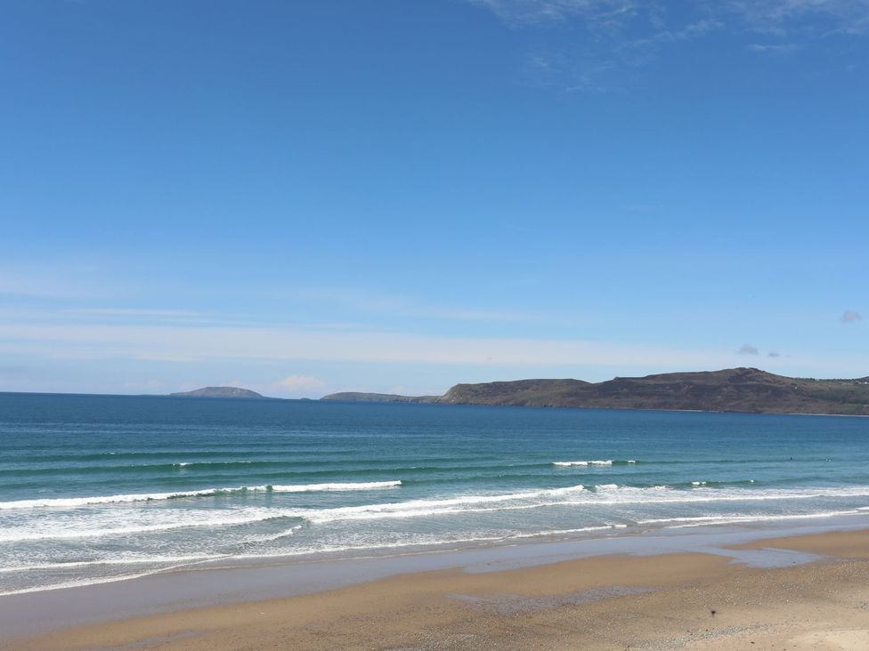 A beach with waves and islands in the distance at Ceiriad - 9 Ty'n Don Llanengan near Abersoch