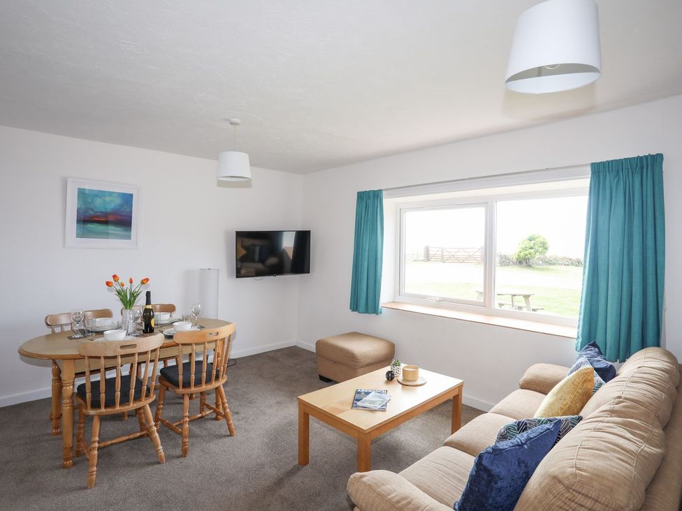 A living room with a dining table and chairs at Oer - 8 Ty'n Don in Llanengan near Abersoch
