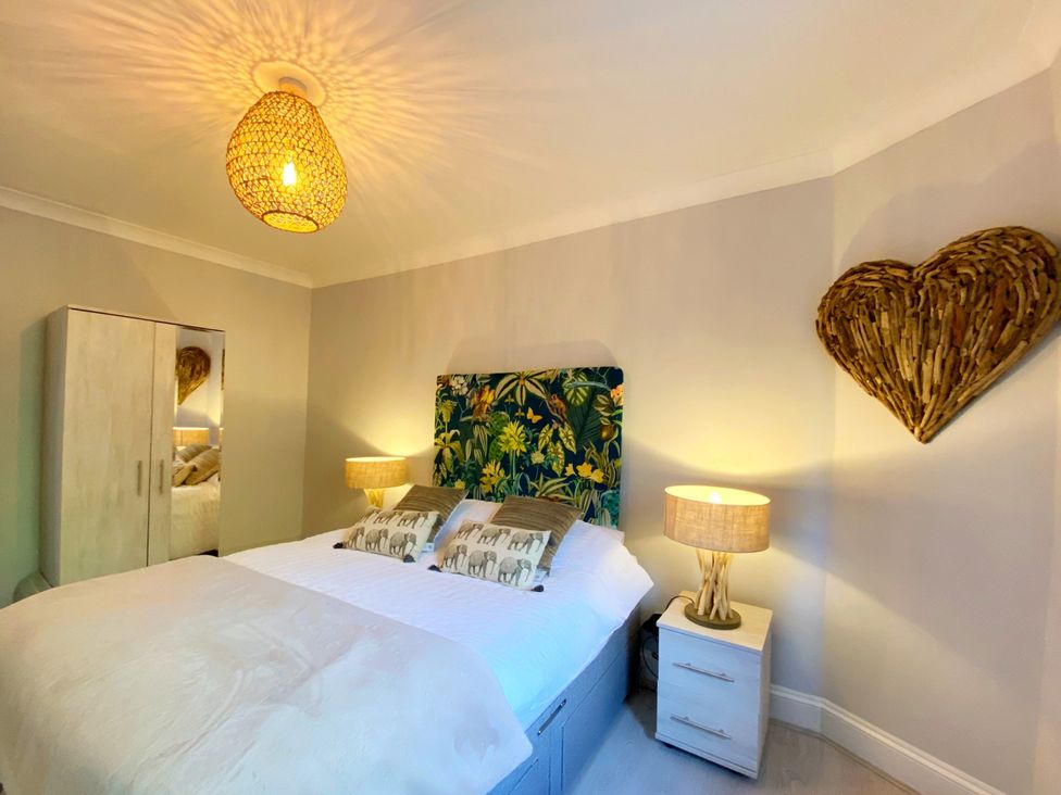 A bedroom with a bed and wardrobe at Meadfoot Bay Apartment at Hesketh Crescent in Torquay