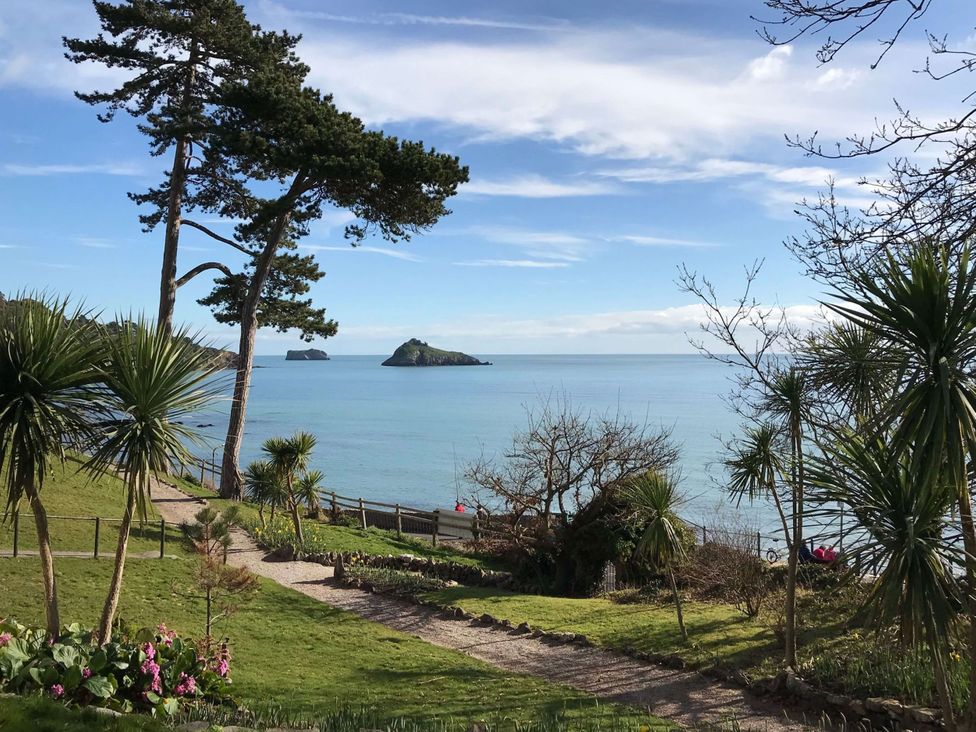 A garden with a path leading to the ocean at Meadfoot Bay Apartment at Hesketh Crescent Torquay
