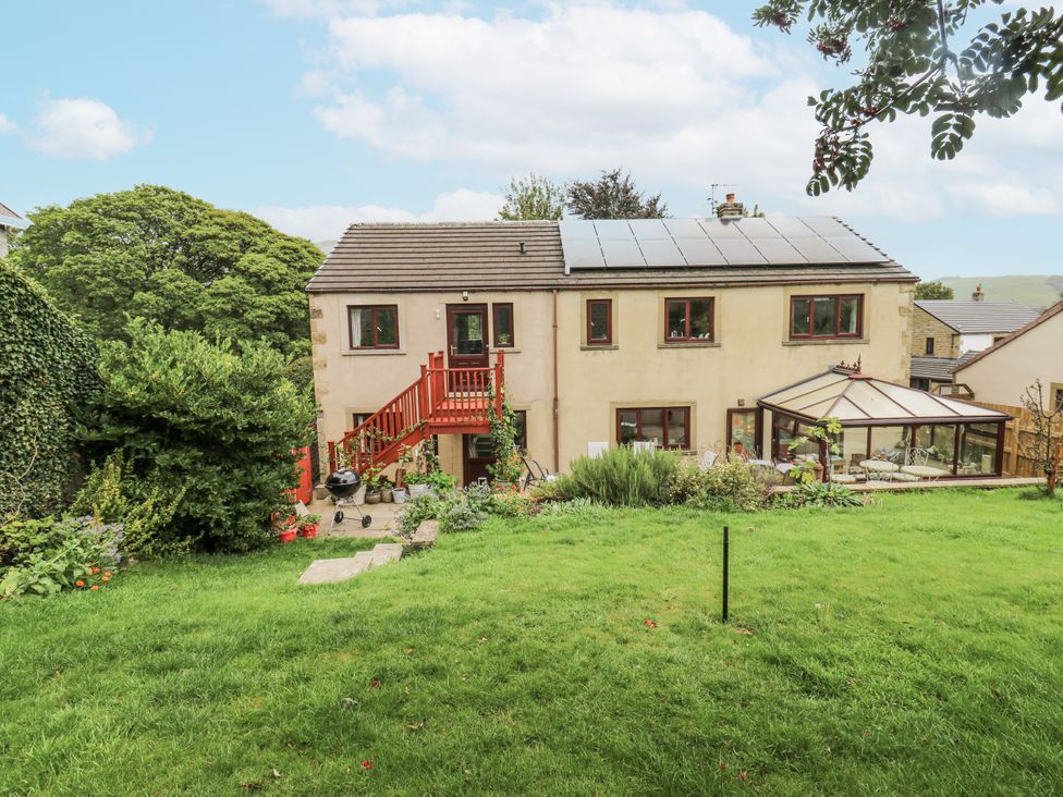 A house with solar panels and a conservatory in the garden at The Treetop 