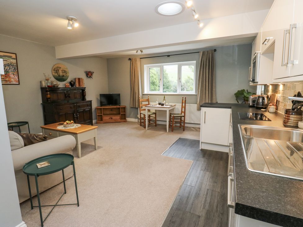A living room with a dining area and kitchen features at The Treetop