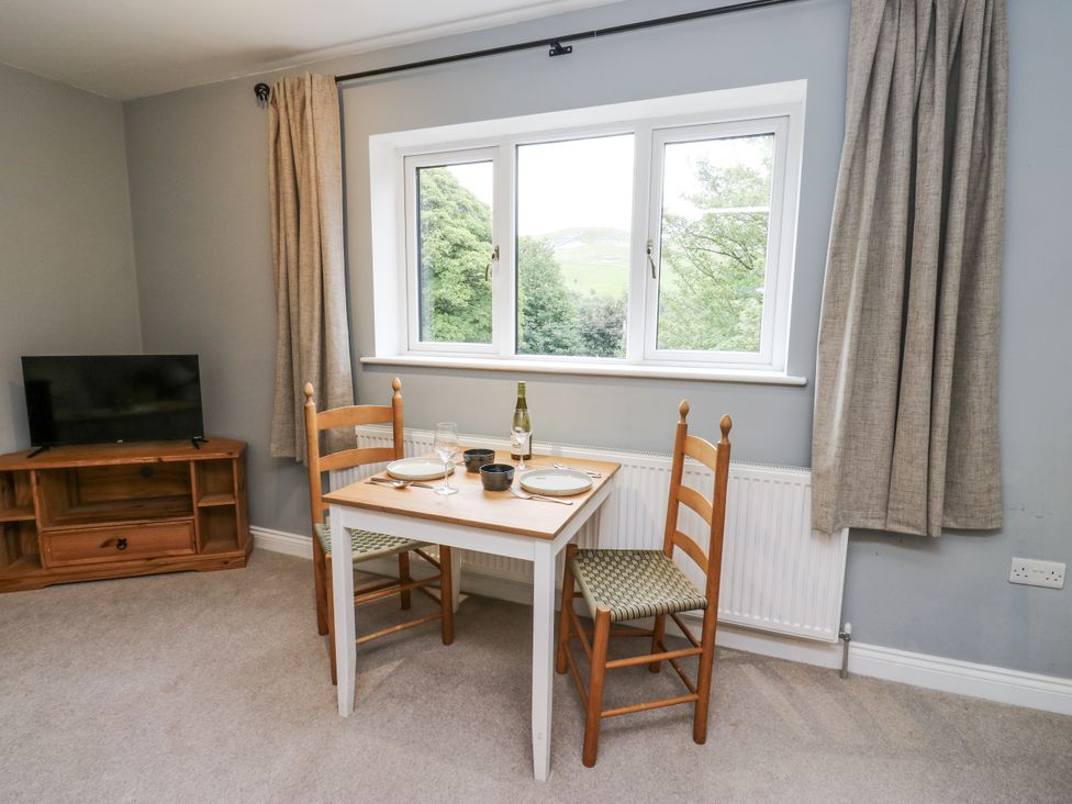 A dining room with a table and chairs next to a window at The Treetop in 