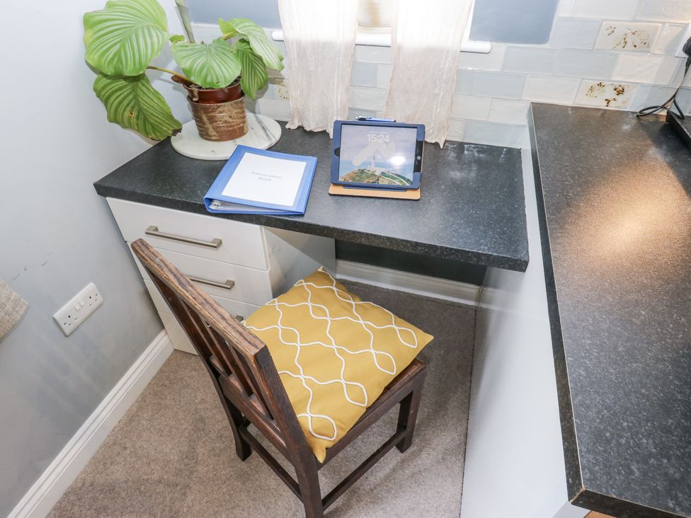 A workspace with a plant and a tablet on the desk at The Treetop 