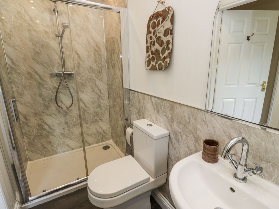 A bathroom with a shower, toilet and sink at The Treetop